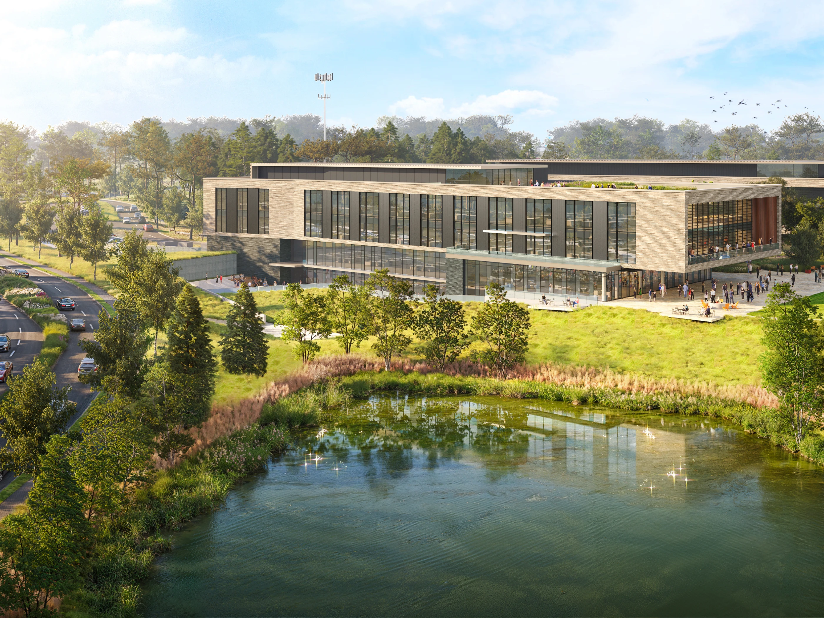 Contemporary office or community center with large windows adjacent to water feature and green parkland