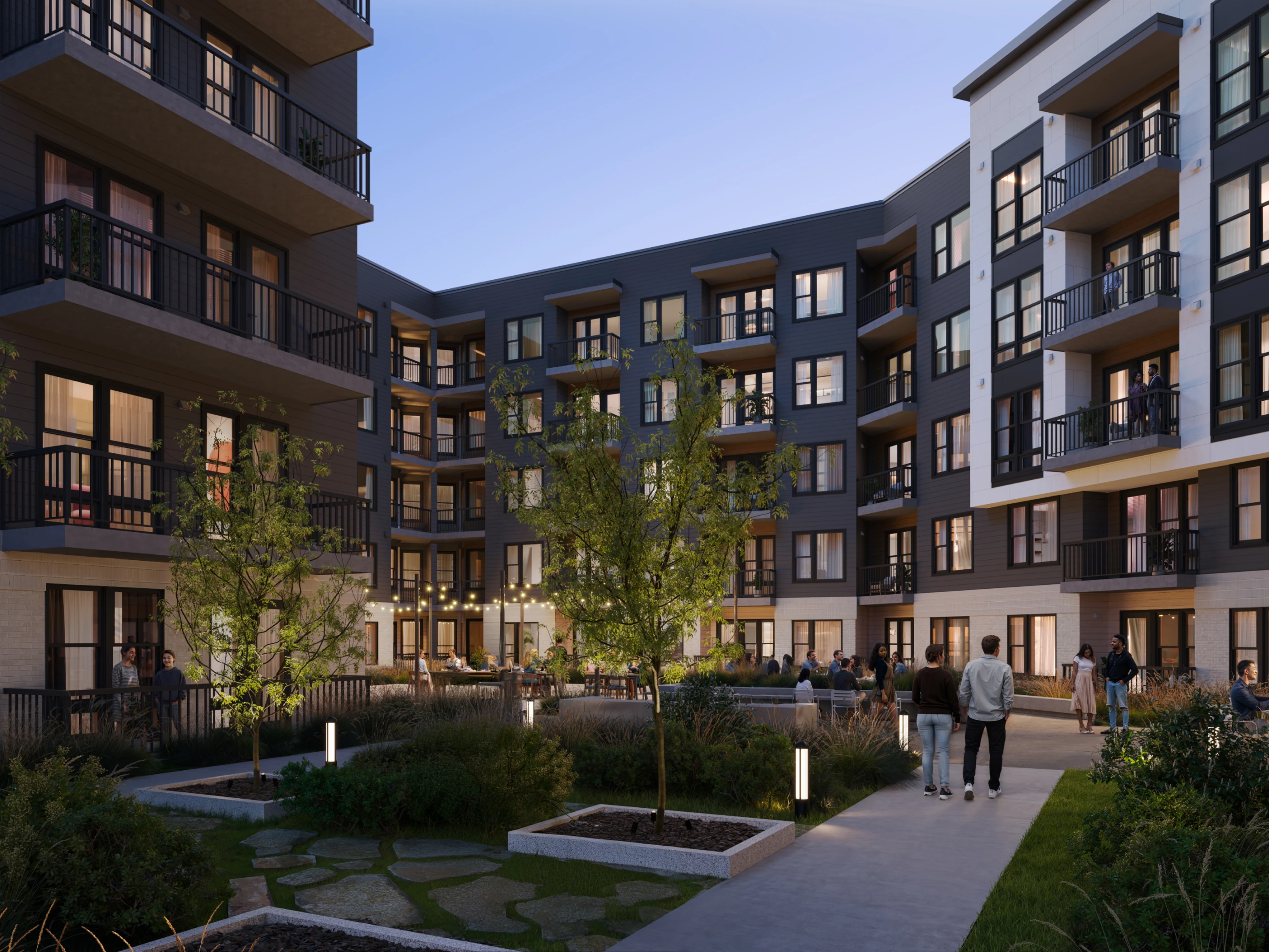 Modern apartment courtyard at dusk featuring landscaped walkways outdoor seating and illuminated community gathering space