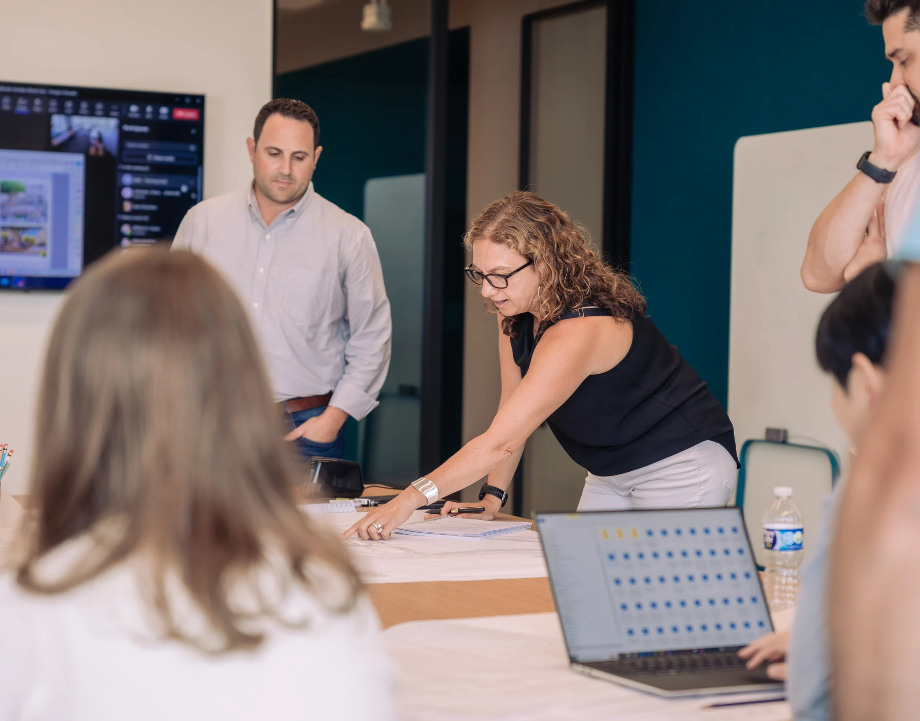 Professionals reviewing development plans in contemporary conference room setting