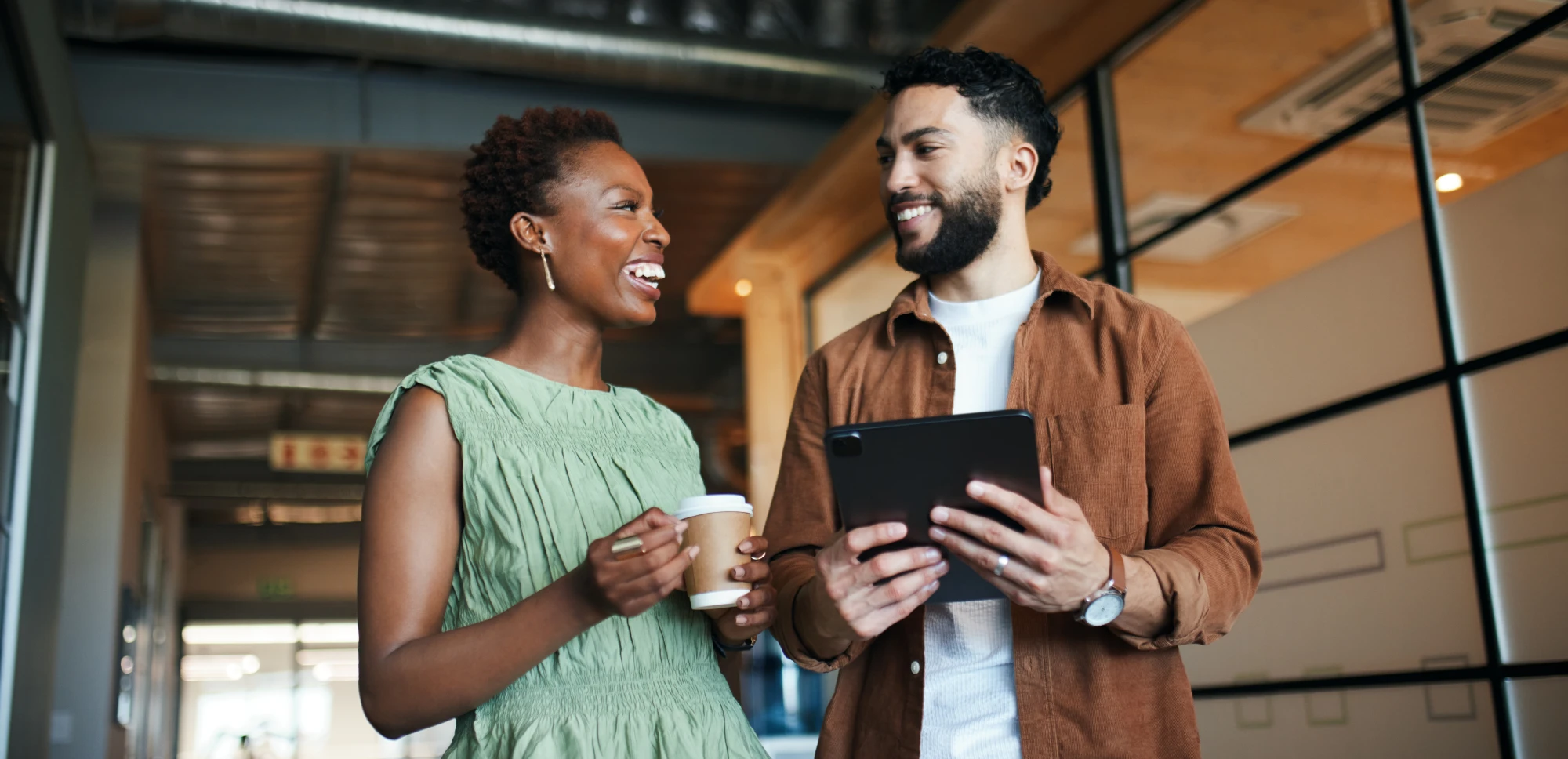 Business professionals collaborating indoors with digital tablet sharing ideas in contemporary workspace environment